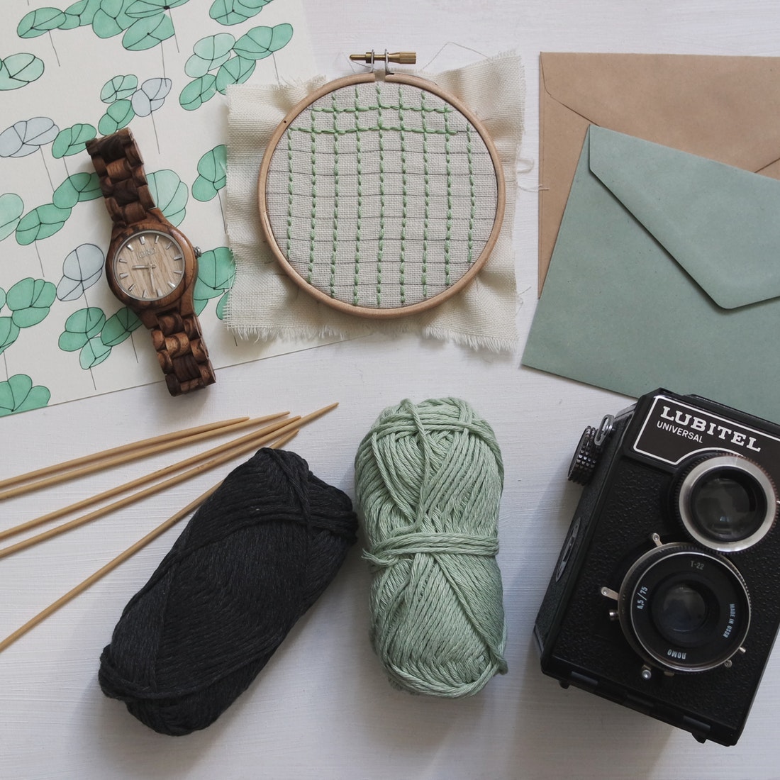 overhead photo of watch, yarn, camera, envelopes
